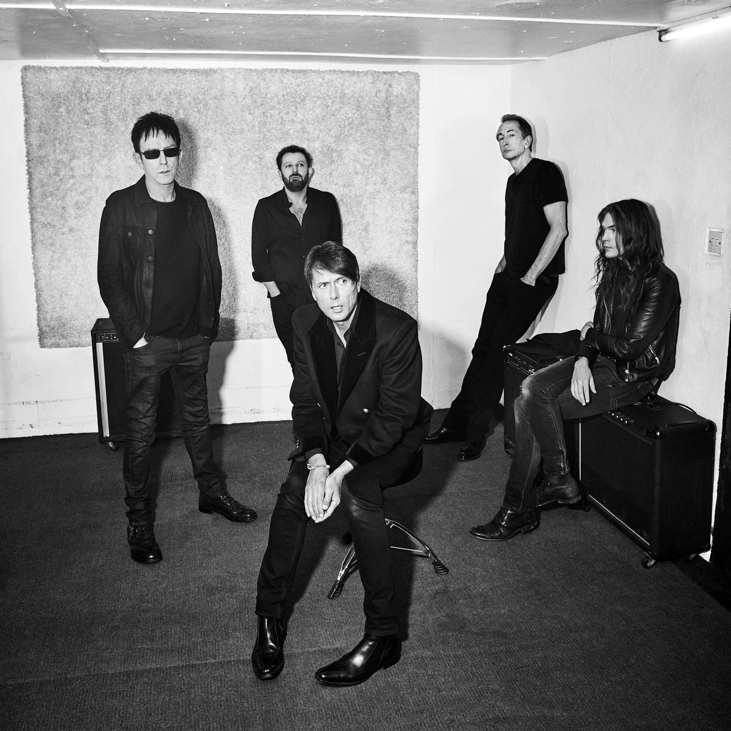 Svartvit bild med fem män som är med i popbandet Suede.