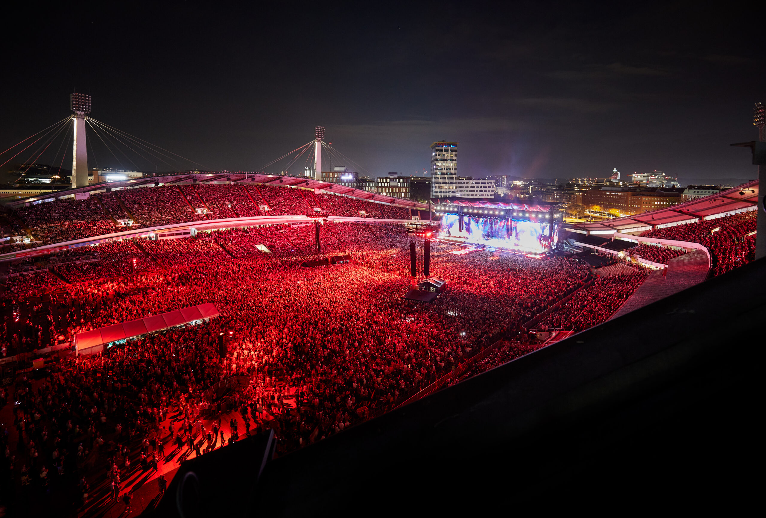 Flygbild över ett fullsatt Ullevi under en konsert, publiken är upplyst av rött ljus
